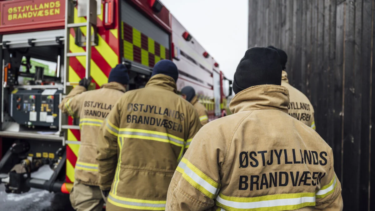 Brandfolk fra Østjyllands Brandvæsen ved en brandbil